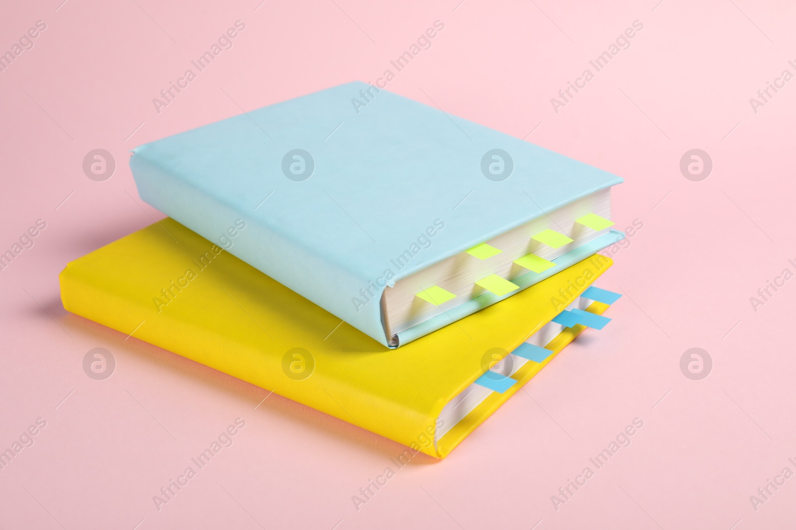 Photo of Books with colorful tabs on pink background