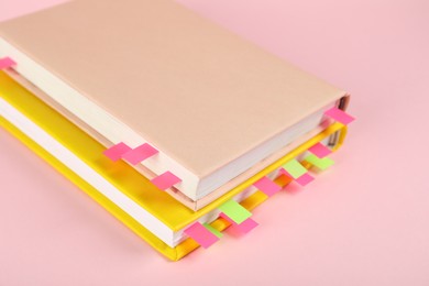 Photo of Books with colorful tabs on pink background, closeup