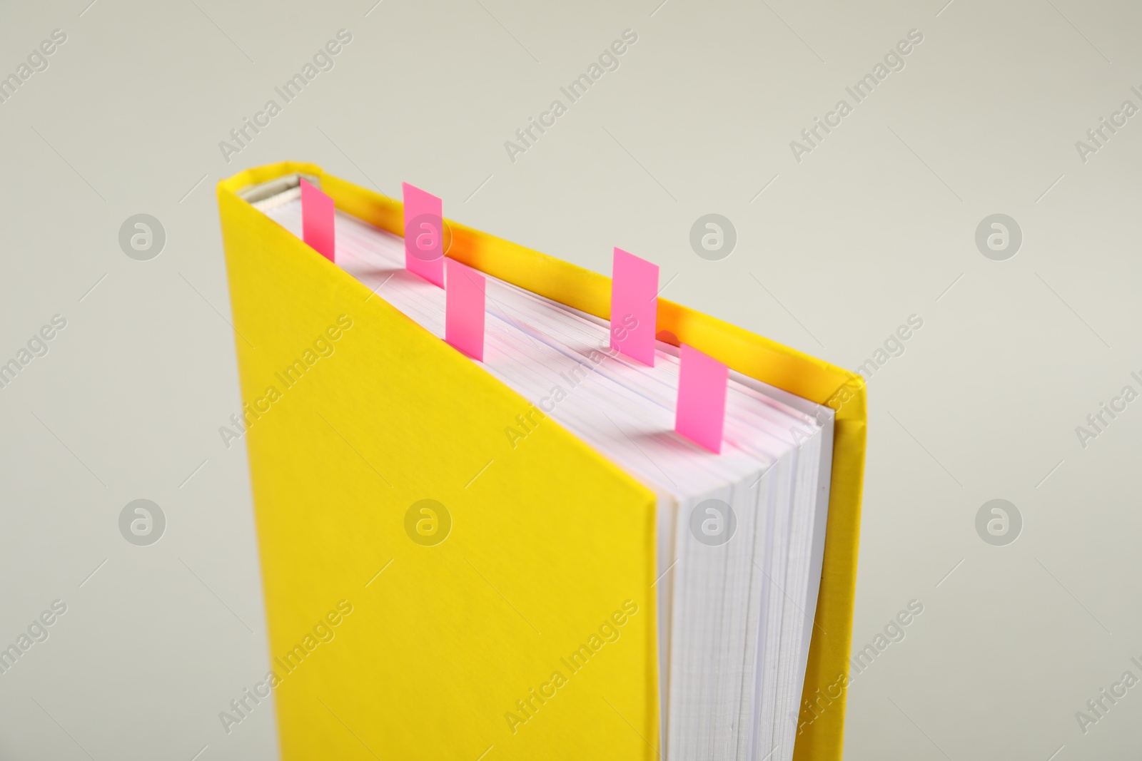 Photo of Book with colorful tabs on light gray background, closeup