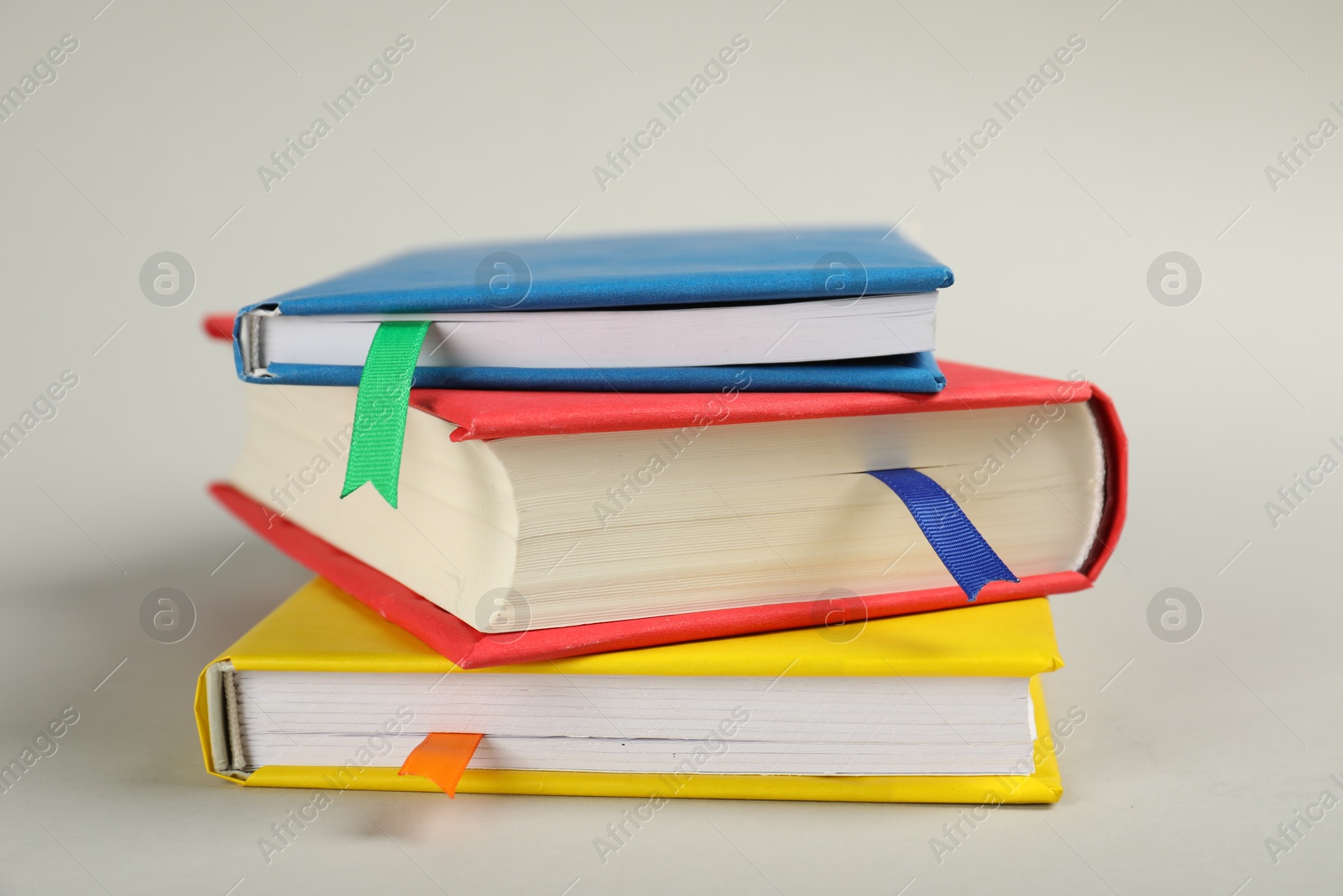 Photo of Books with colorful tabs on light gray background, closeup