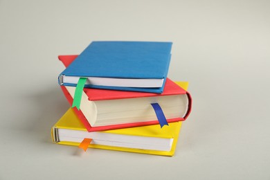 Photo of Books with colorful tabs on light gray background, closeup