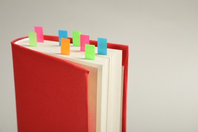 Photo of Book with colorful tabs on light gray background, closeup