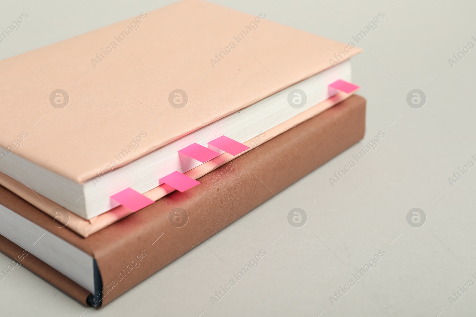 Photo of Books with colorful tabs on light gray background, closeup