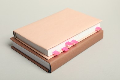 Photo of Books with colorful tabs on light gray background, closeup