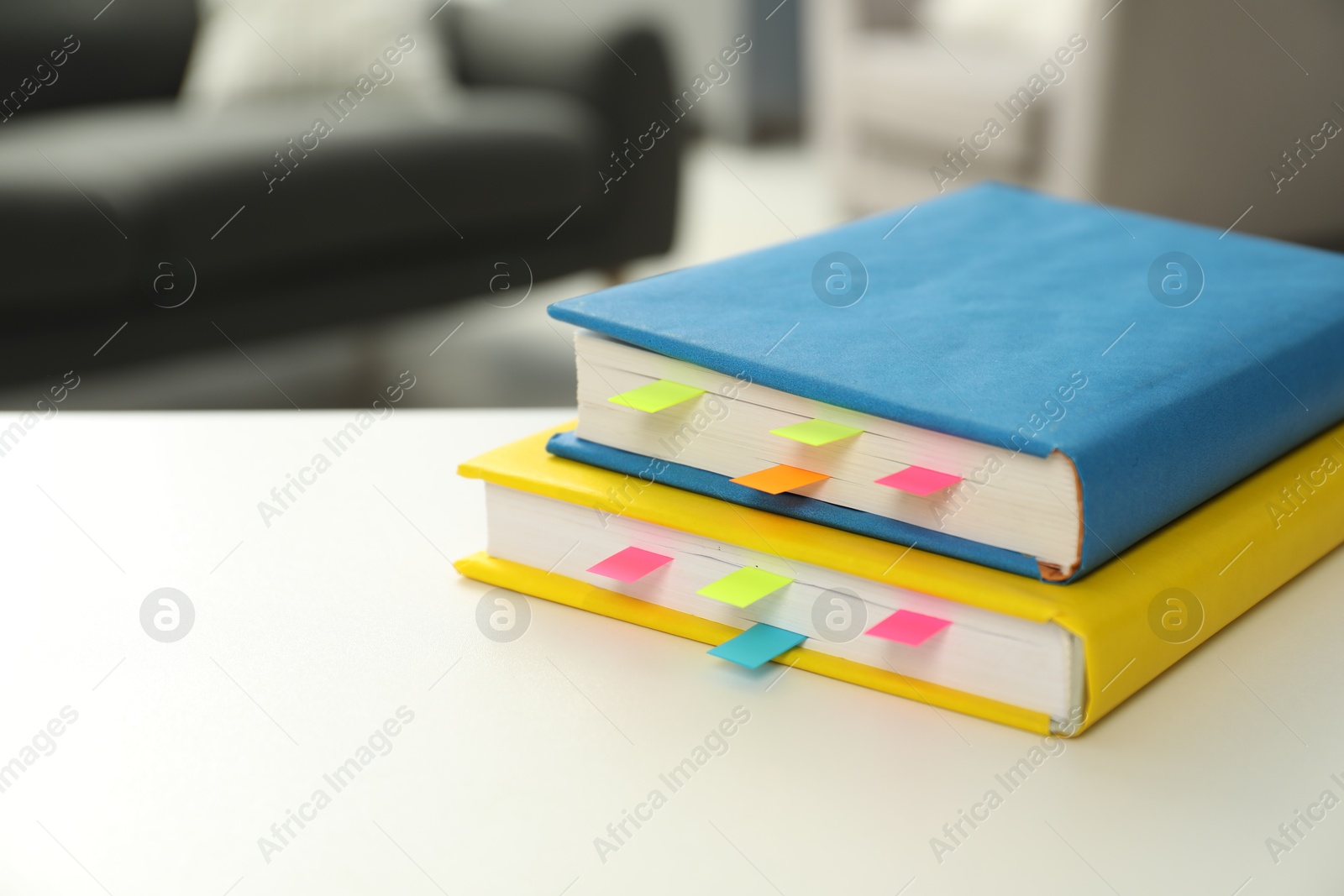 Photo of Books with colorful tabs on light table, closeup. Space for text