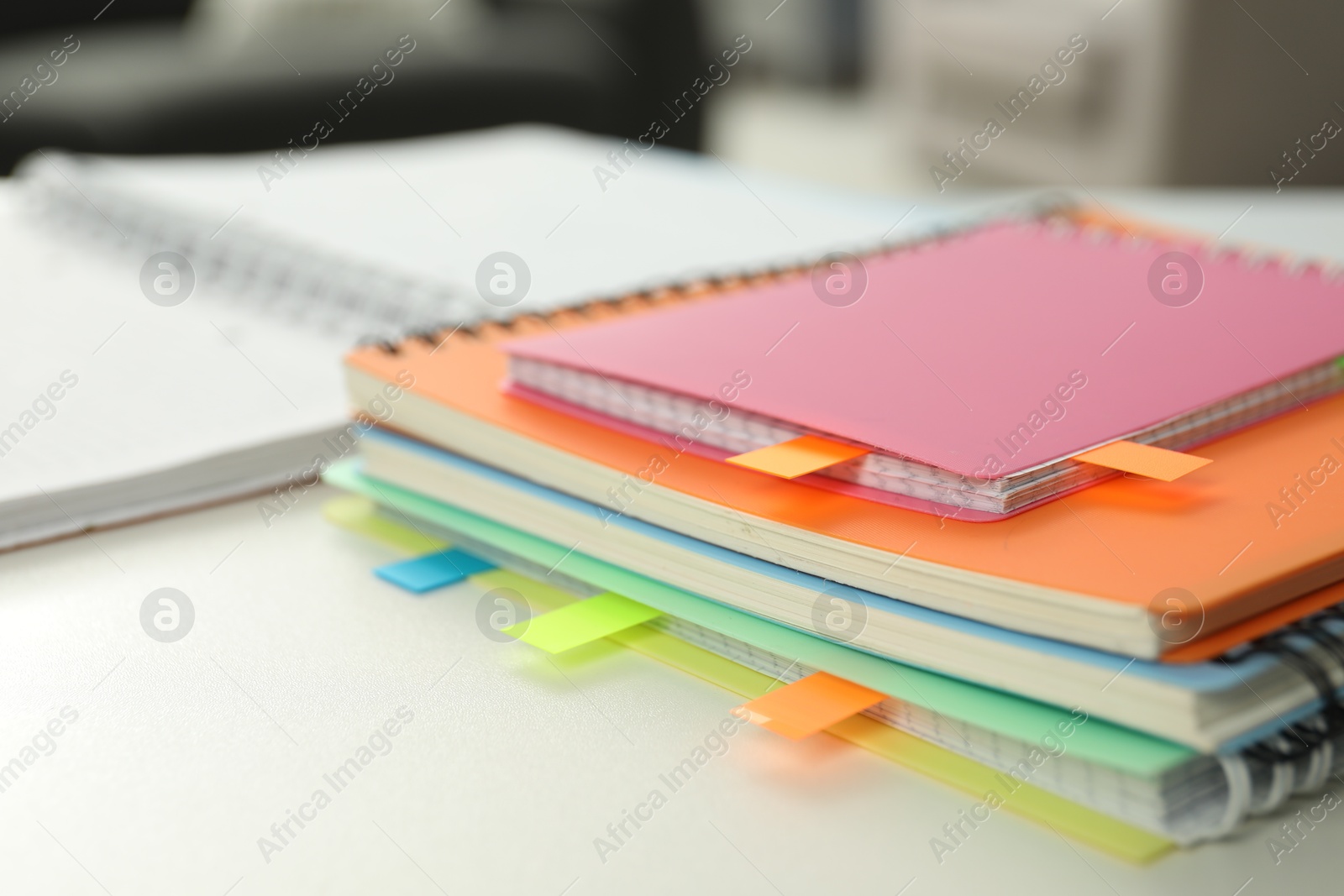 Photo of Notebooks with colorful tabs on light table, closeup