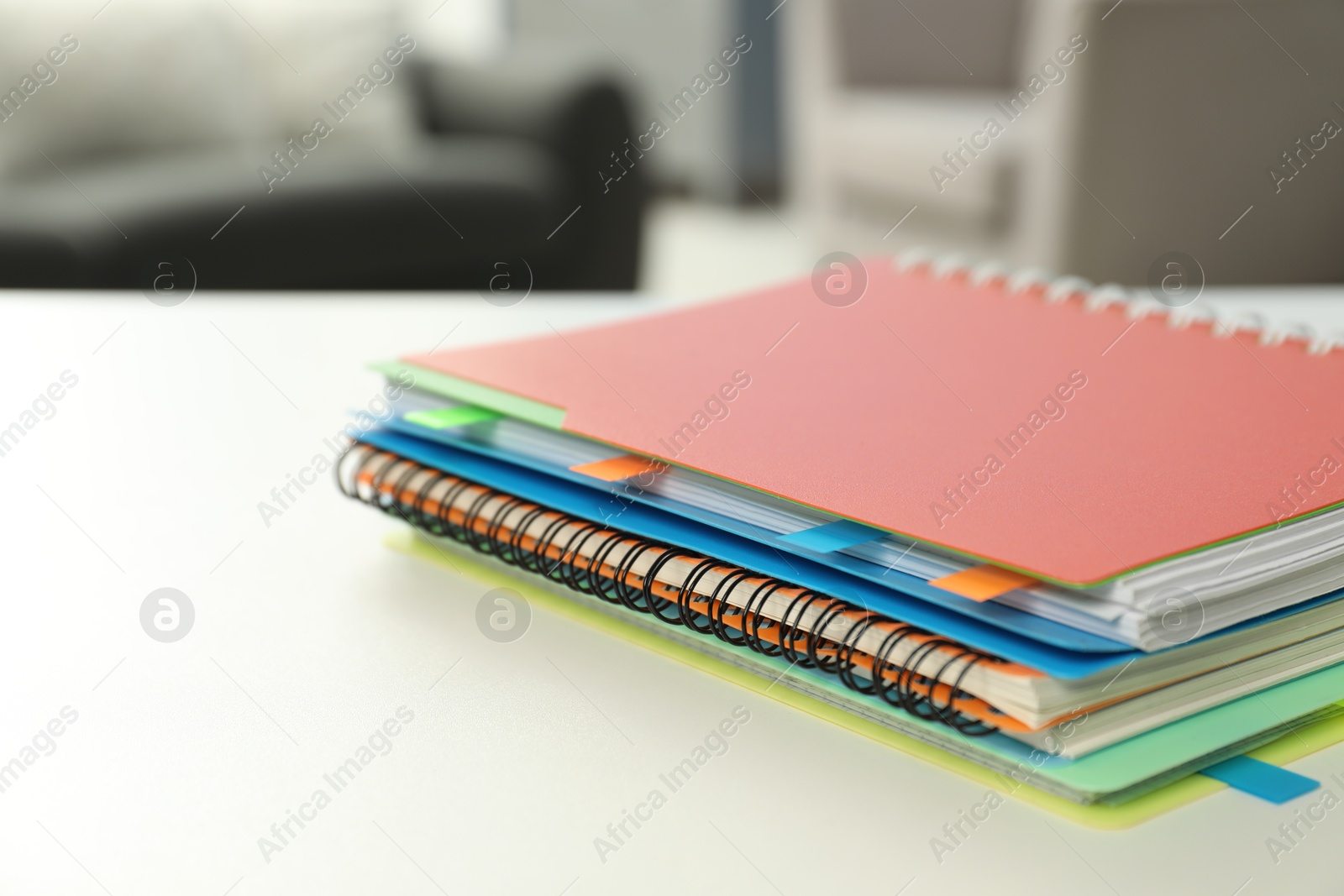 Photo of Notebooks with colorful tabs on light table, closeup