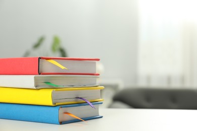 Photo of Books with ribbon bookmarks on light table indoors, space for text