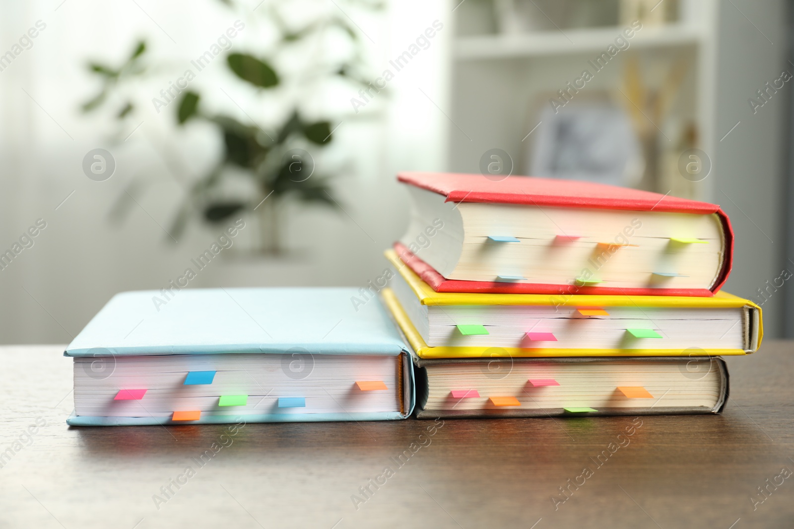 Photo of Books with colorful tabs on wooden table indoors