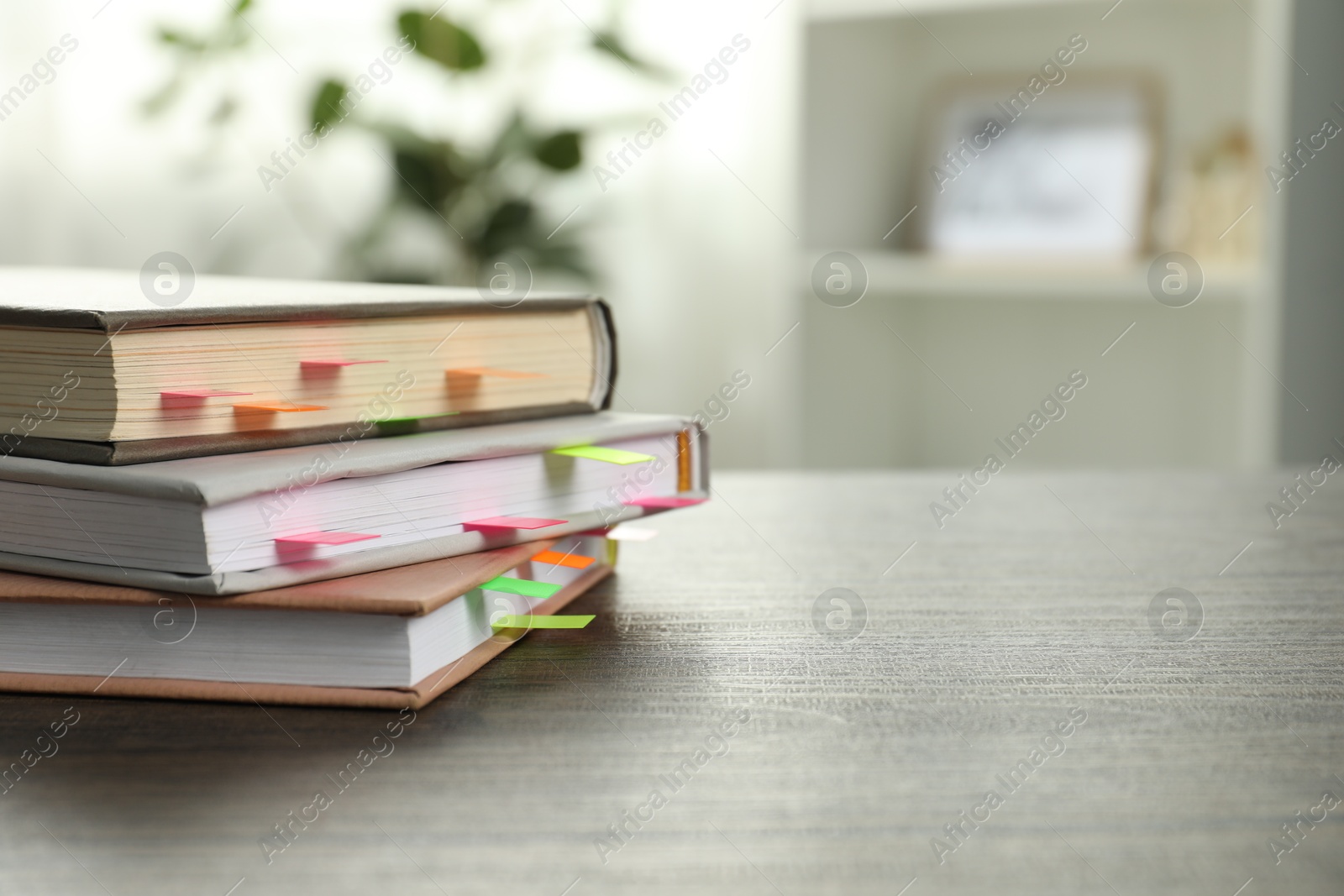 Photo of Books with colorful tabs on wooden table indoors, space for text