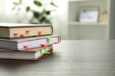 Photo of Books with colorful tabs on wooden table indoors, space for text