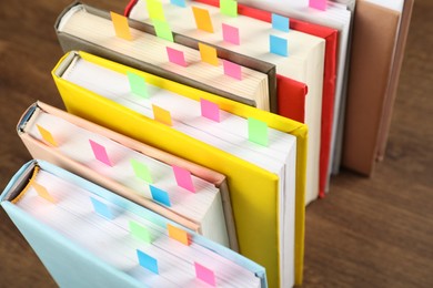 Photo of Books with colorful tabs on brown table, closeup