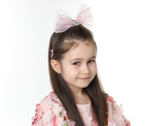 Photo of Smiling little girl wearing beautiful hair accessories on white background