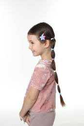 Photo of Little girl wearing beautiful hair accessories on white background