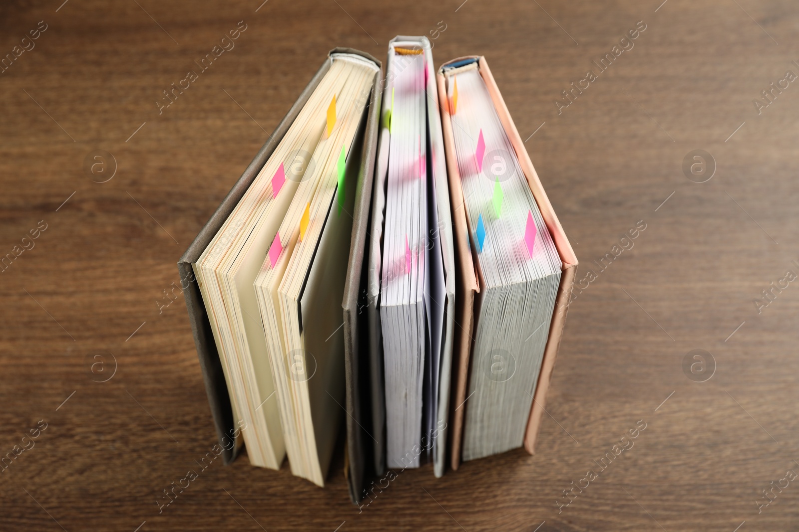 Photo of Books with colorful tabs on wooden table