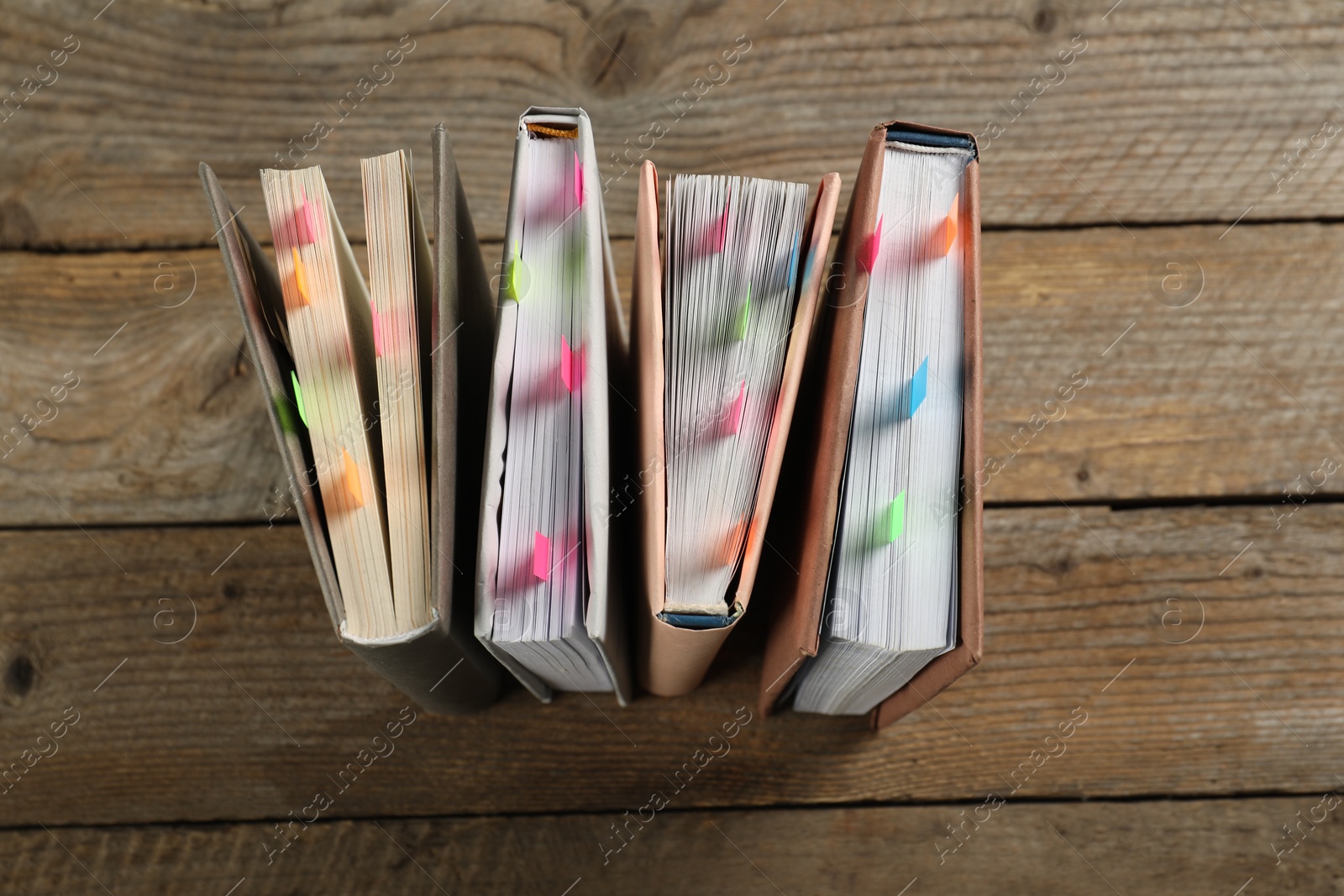 Photo of Books with colorful tabs on wooden table, top view