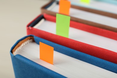 Photo of Books with colorful tabs on light background, closeup