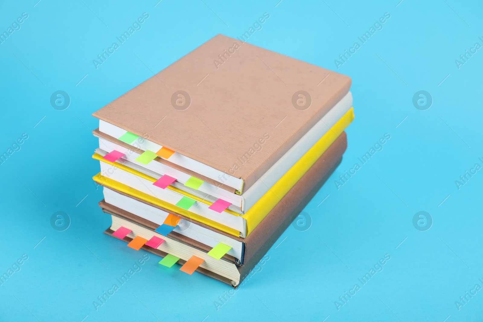 Photo of Books with colorful tabs on light blue background