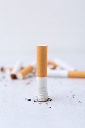 Photo of Cigarette butts on light background, selective focus