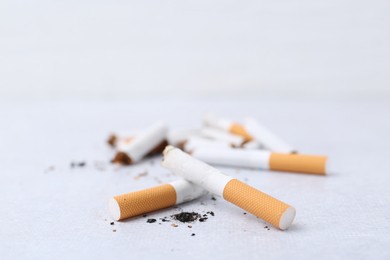 Photo of Cigarette butts on light background, selective focus