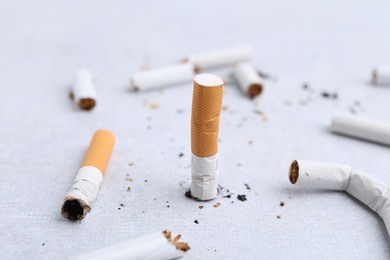 Photo of Many cigarette butts on light background. Smoking habit