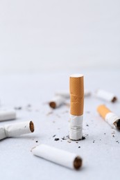 Photo of Many cigarette butts on light background. Smoking habit