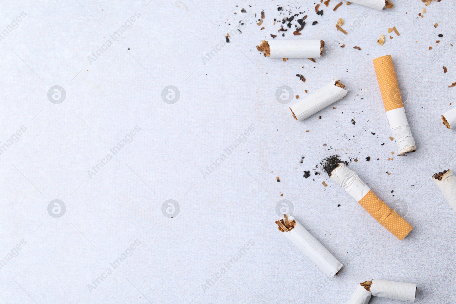 Photo of Many cigarette butts on light gray background, flat lay. Space for text