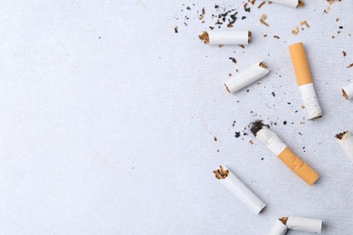 Photo of Many cigarette butts on light gray background, flat lay. Space for text