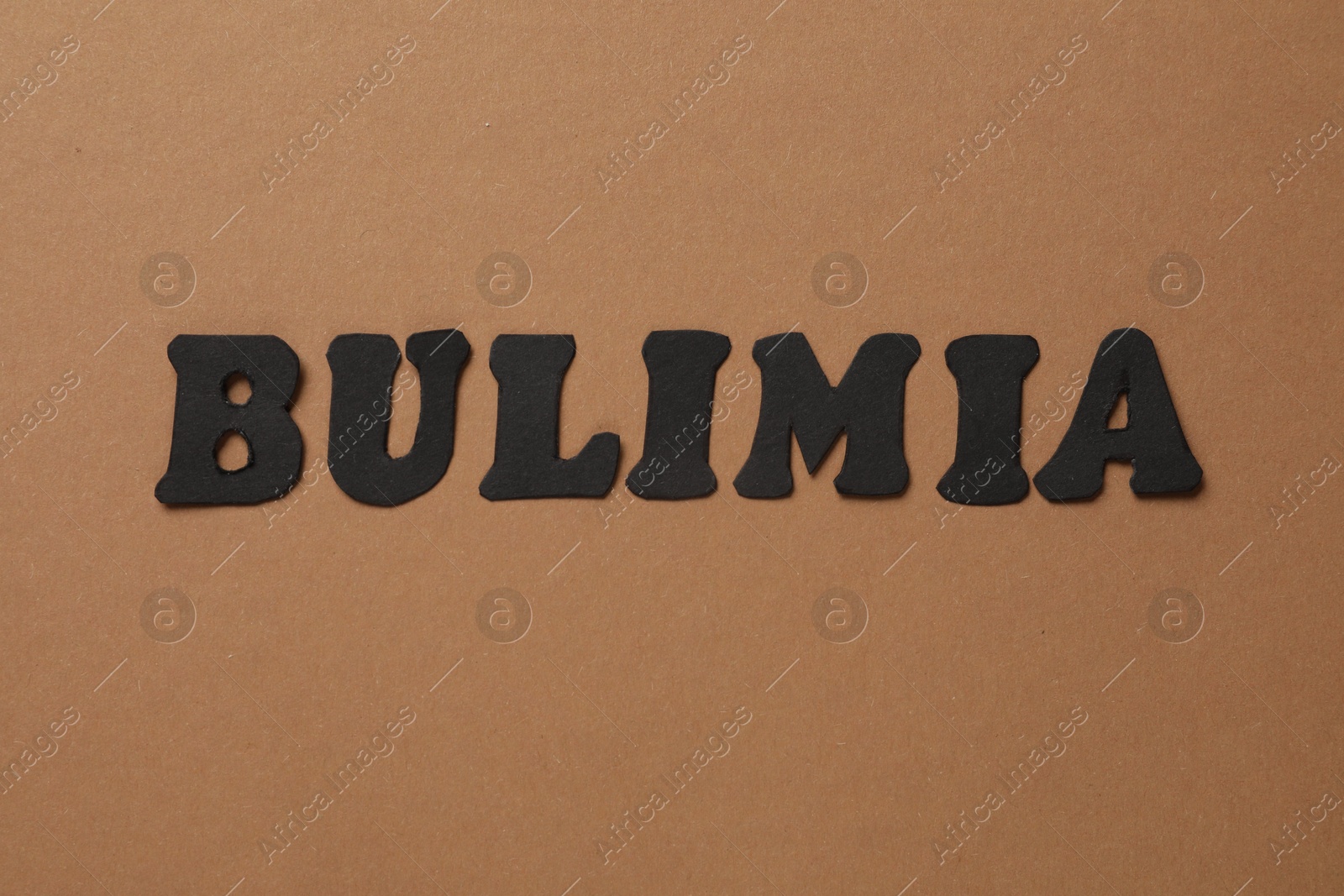 Photo of Word Bulimia on brown background, top view