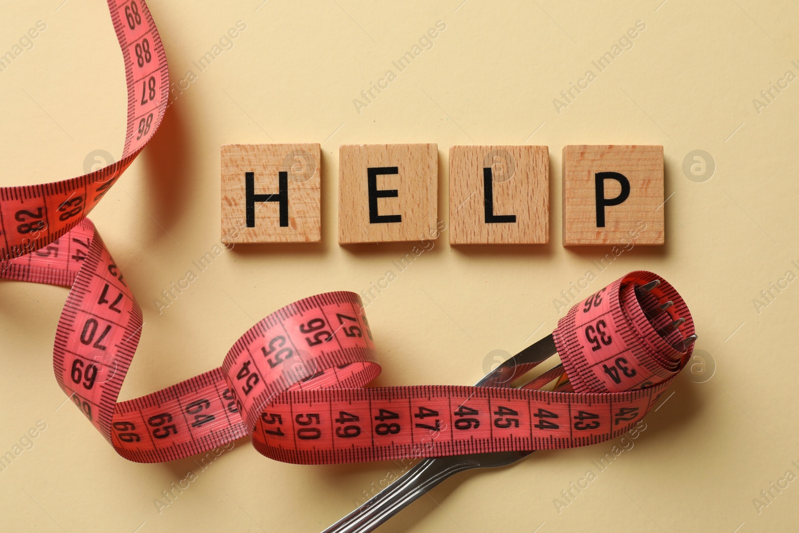 Photo of Bulimia. Word Help, fork and measuring tape on beige background, top view