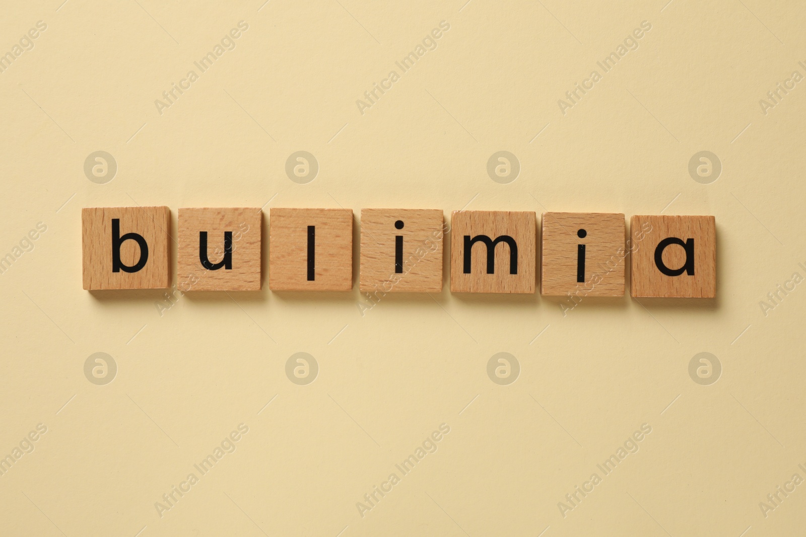 Photo of Word Bulimia on beige background, top view