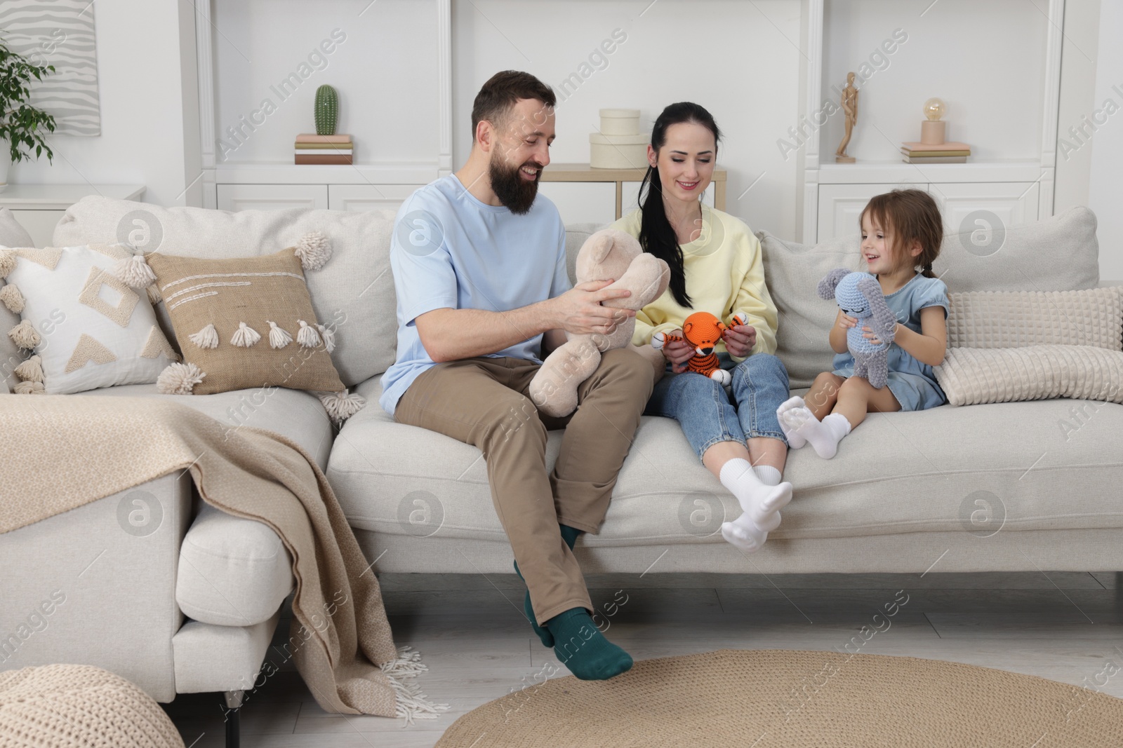 Photo of Cute little girl and her parents spending time together at home