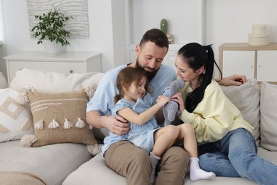 Photo of Cute little girl and her parents spending time together at home