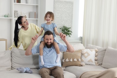 Photo of Cute little girl and her parents having fun at home