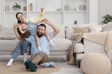 Photo of Cute little girl and her parents having fun at home