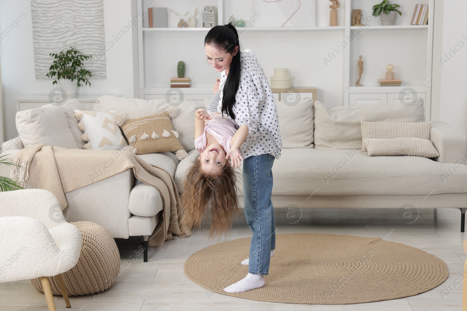 Photo of Cute little girl and her mother having fun at home