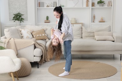 Photo of Cute little girl and her mother having fun at home