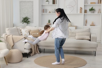 Photo of Cute little girl and her mother having fun at home