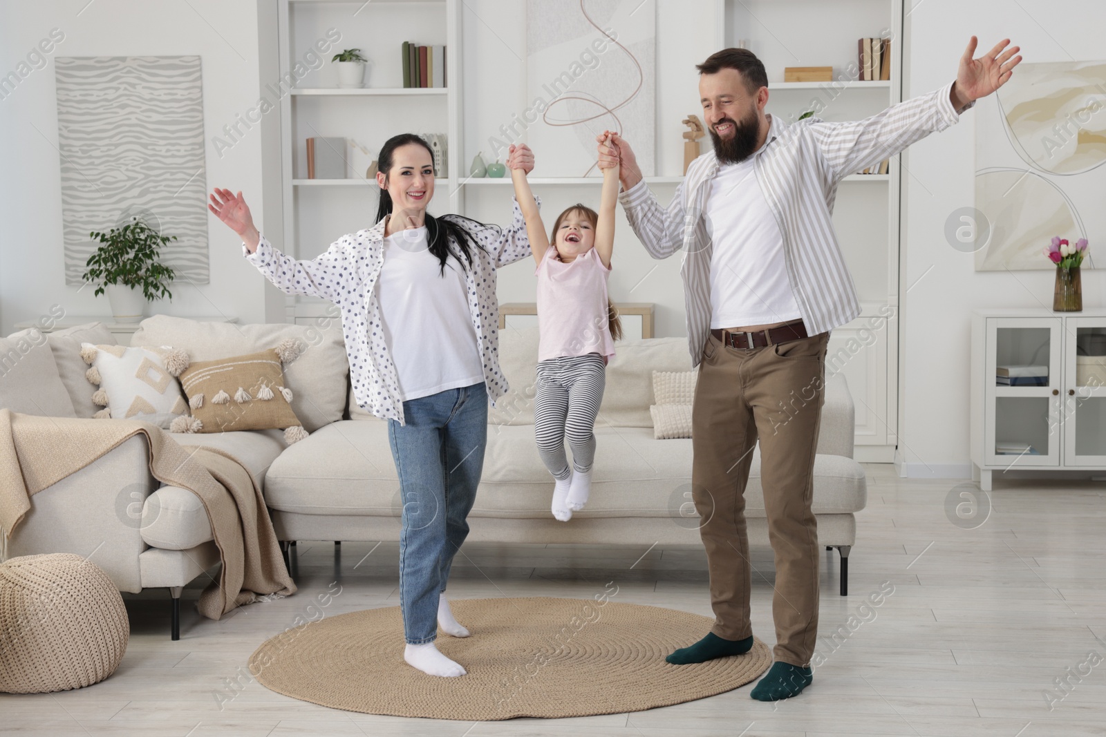 Photo of Cute little girl and her parents having fun at home