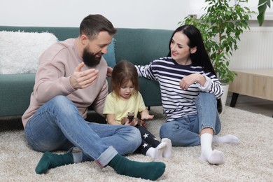 Photo of Parents and their cute little daughter playing ukulele at home