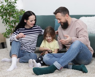 Photo of Parents and their cute little daughter playing ukulele at home