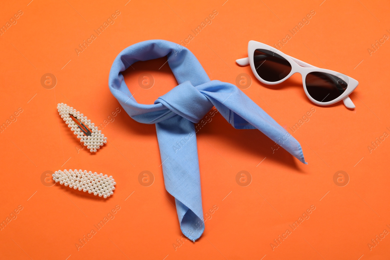 Photo of Stylish accessories on orange background, flat lay