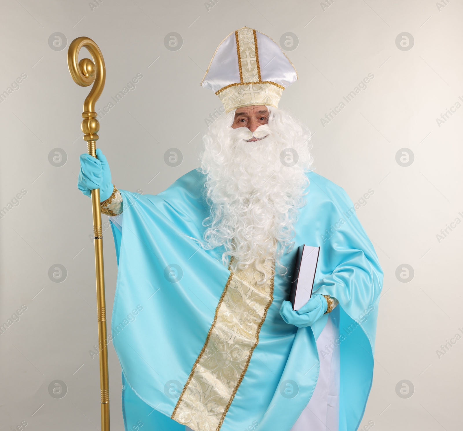 Photo of Saint Nicholas with book and crozier on gray background