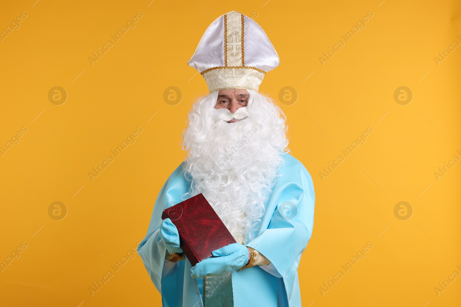 Photo of Saint Nicholas with book on orange background