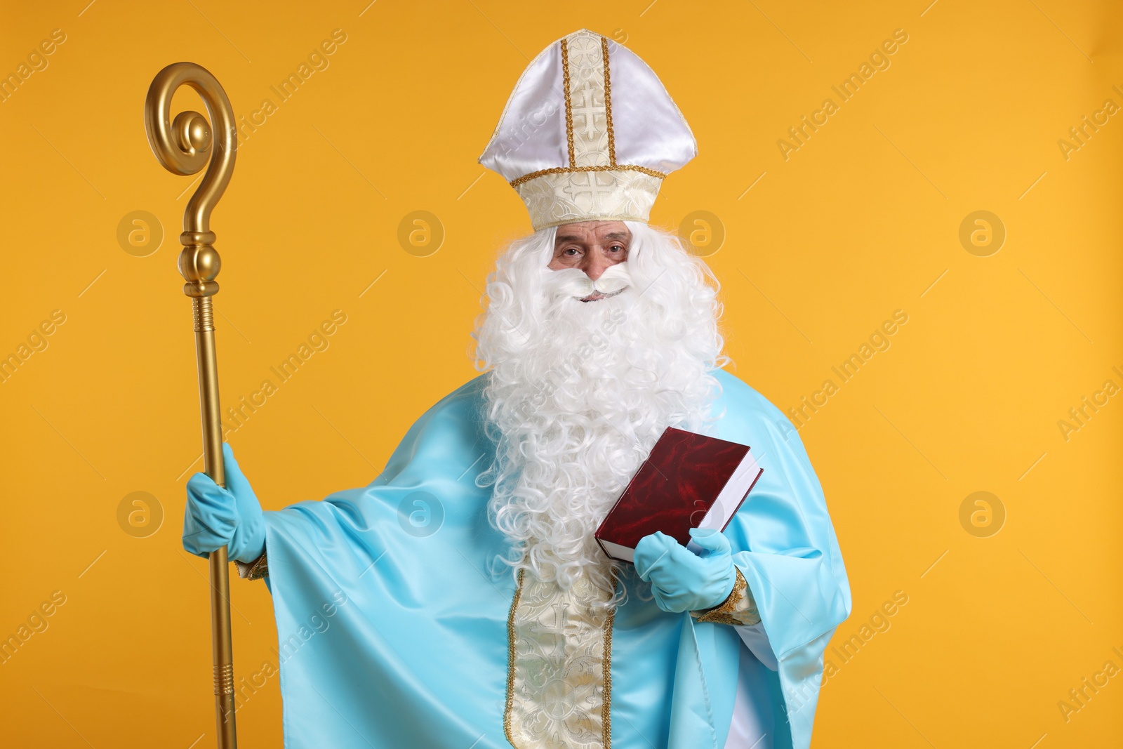 Photo of Saint Nicholas with crozier and book on orange background