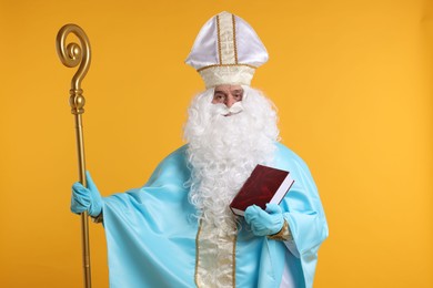 Photo of Saint Nicholas with crozier and book on orange background