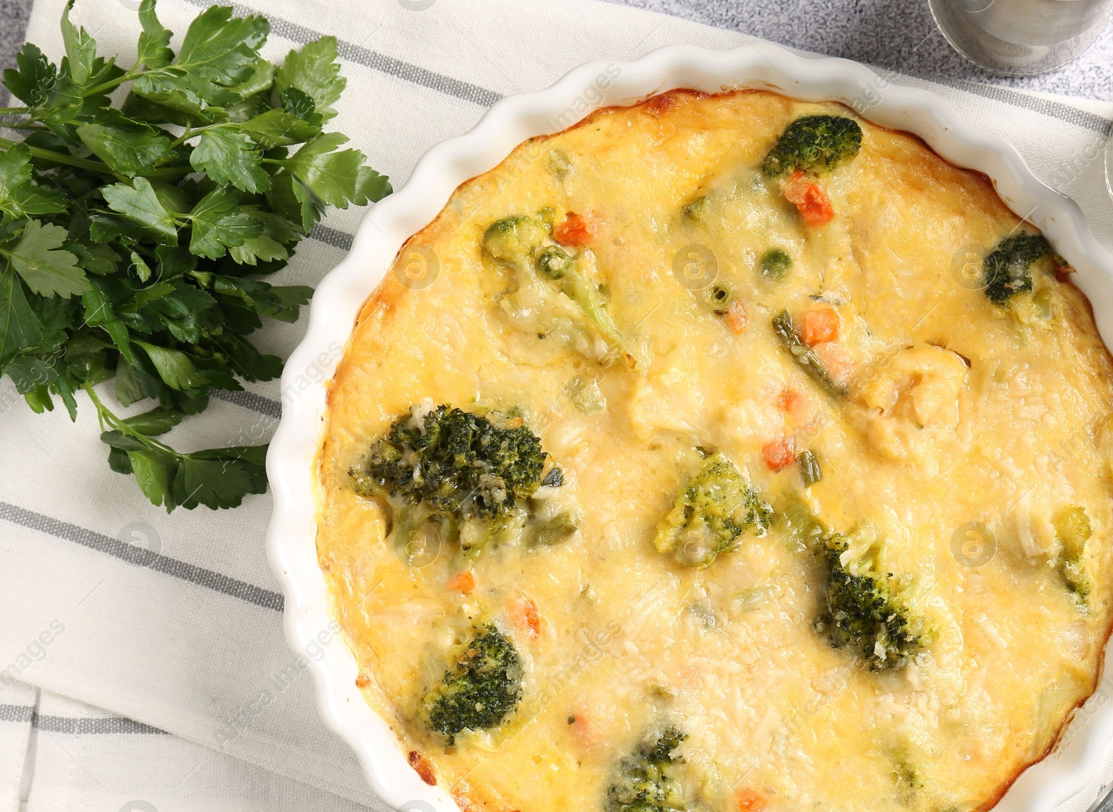 Photo of Delicious vegetable casserole and parsley on light table, top view