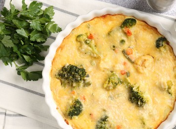 Photo of Delicious vegetable casserole and parsley on light table, top view