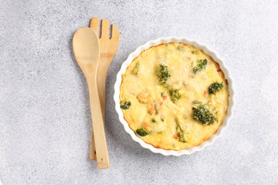 Photo of Delicious vegetable casserole and utensils on light table, top view