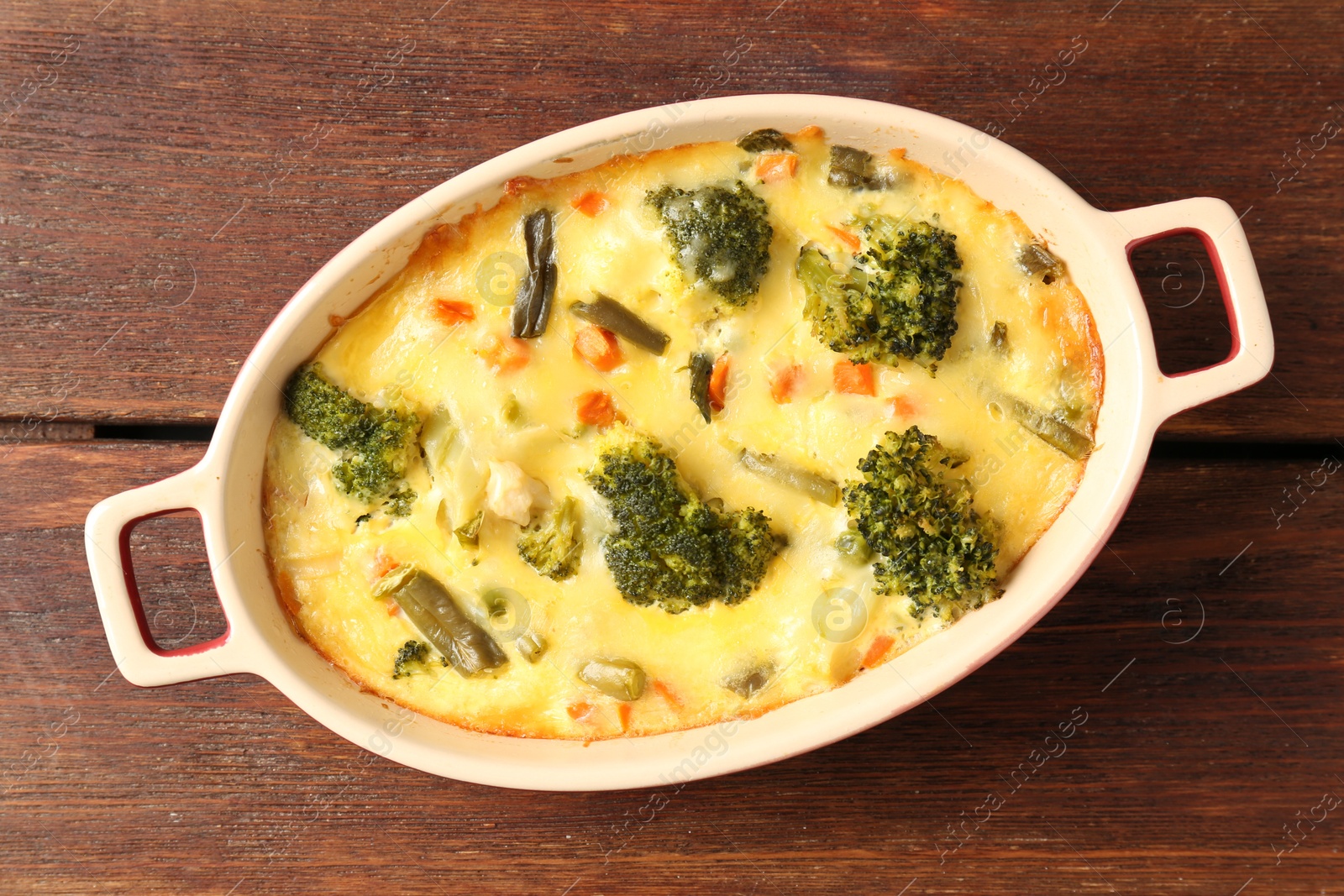 Photo of Delicious vegetable casserole on wooden table, top view